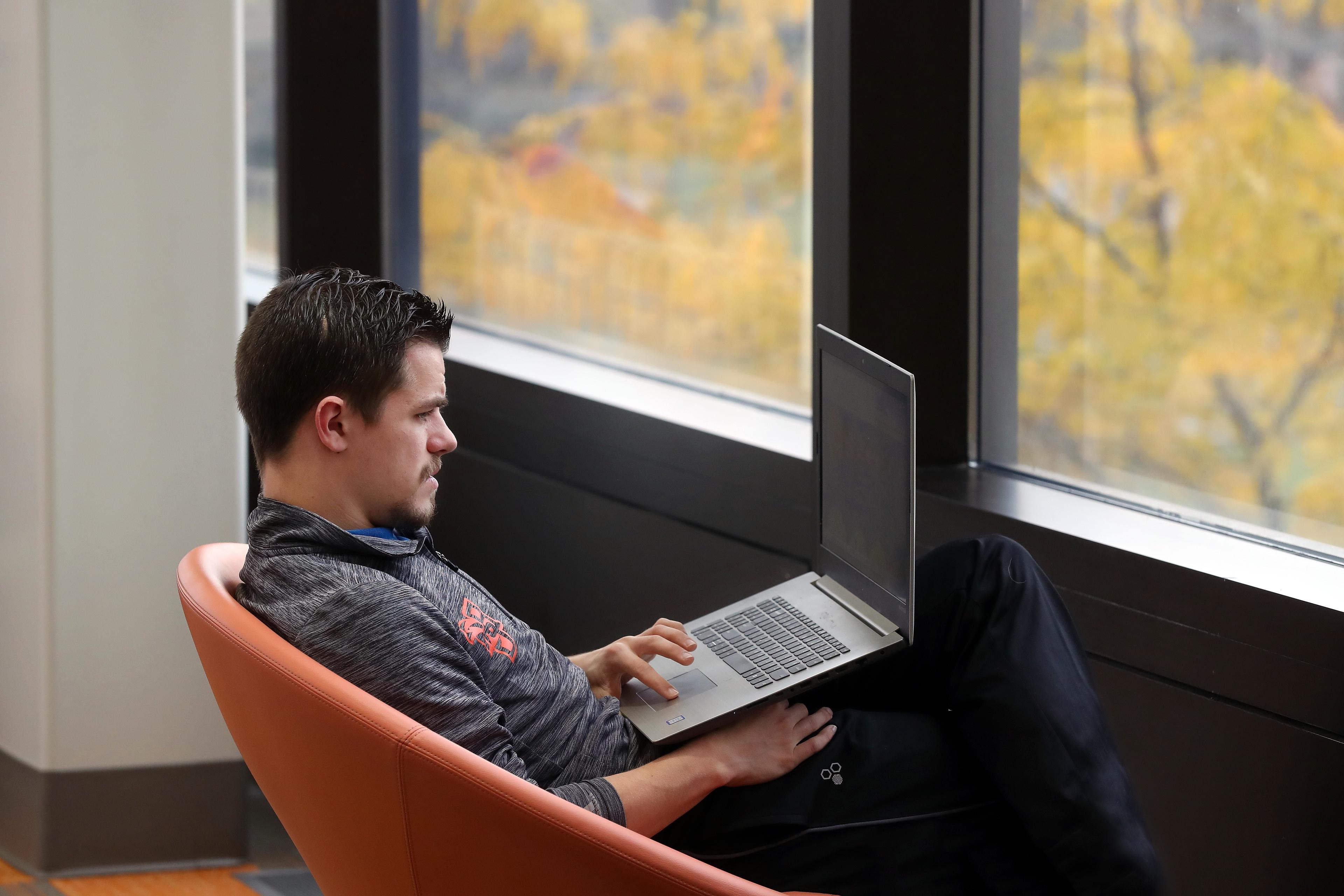 student-with-laptop-sitting-near-window
